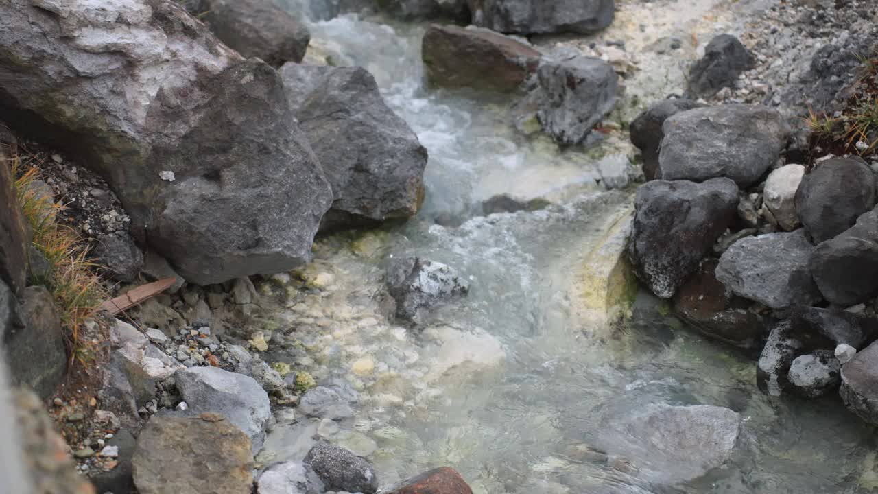 近景的自然景观和多摩川温泉的治疗质量在秋田，东北。含硫矿物的清水流过地表下可见的岩石，增添了宁静的气氛。视频素材