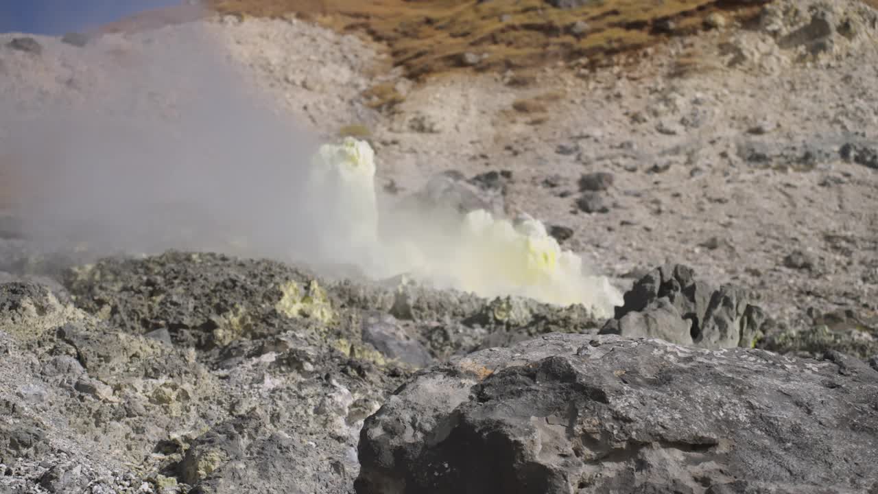 近距离拍摄的化石和煤炭残骸与岩石高地覆盖的重硫蒸汽，表明在日本东北秋田的玉川温泉自然和人类元素的结合。视频素材