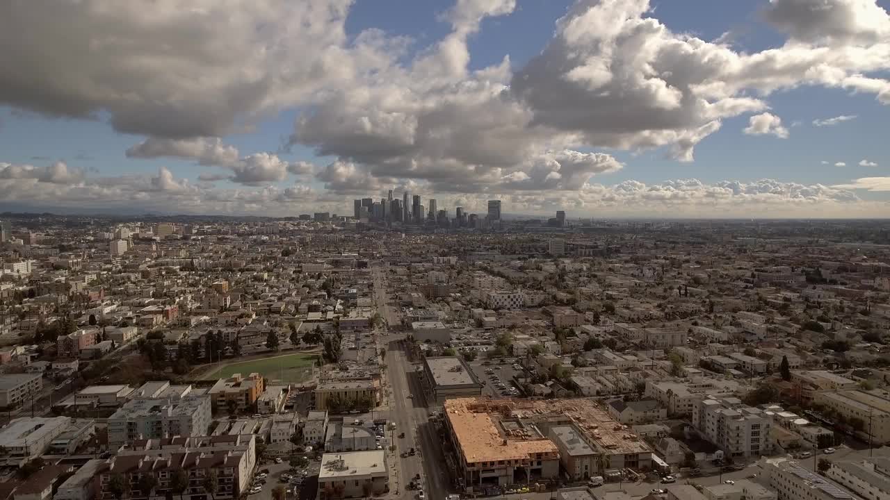 在多云的天空下，住宅在市中心办公大楼的航拍，无人机在晴朗的日子向后飞行-洛杉矶，加利福尼亚视频素材