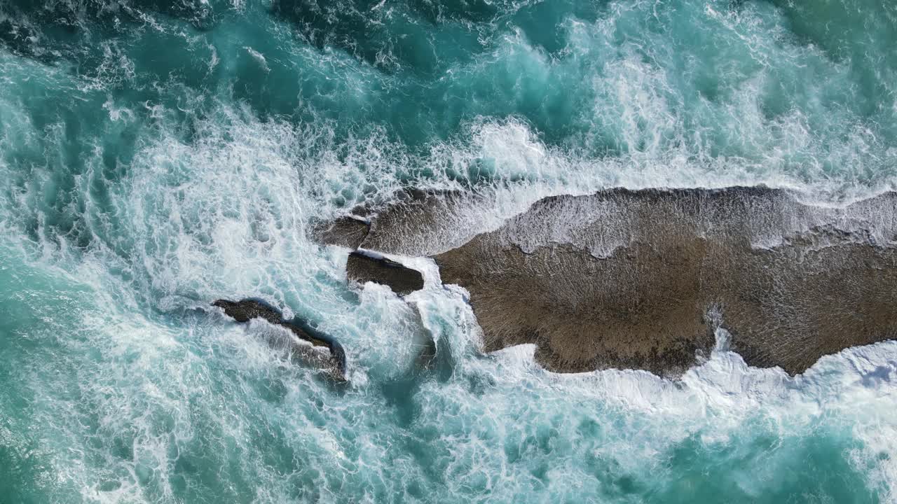 海浪有规律地冲击着岩石海滩视频下载