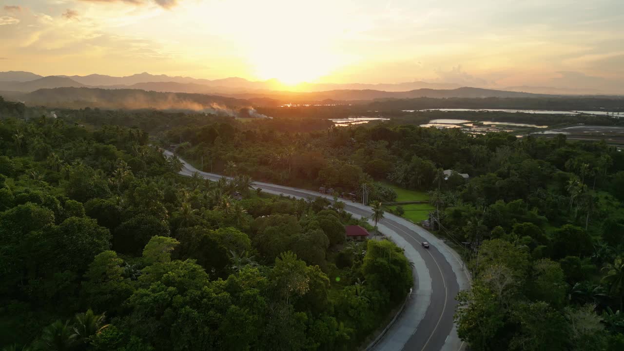热带乡村，树木环绕着夕阳下的道路视频素材