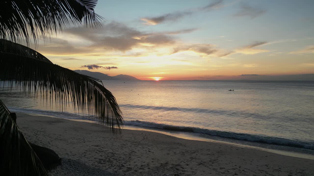 热带夏季日落时海岸附近平静的海浪视频素材
