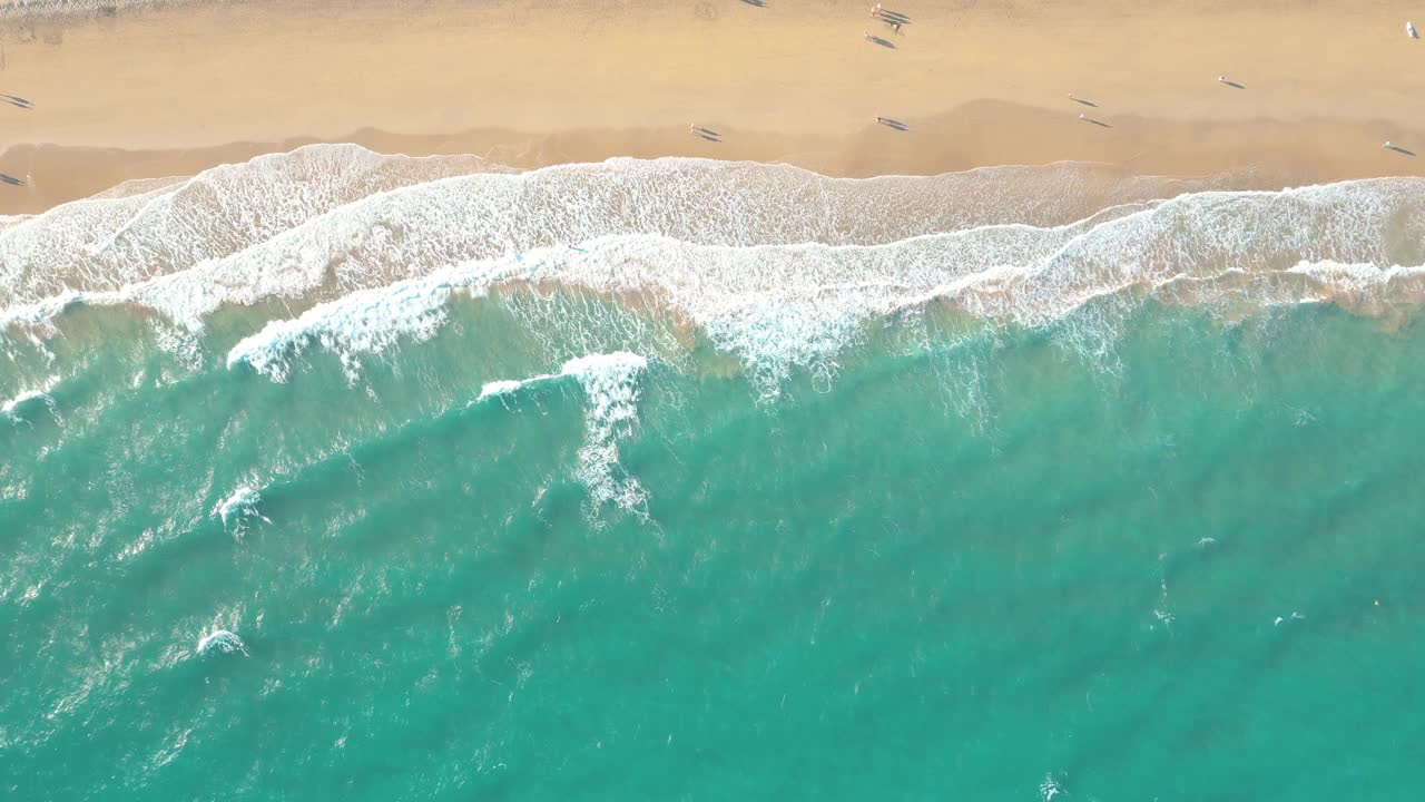 夏天的海景美丽的波浪，蓝色的海水在阳光明媚的日子。西班牙，加那利岛，埃斯昆佐海滩。海上鸟瞰图，热带自然美丽明亮的海浪飞溅和沙滩沙滩夕阳视频素材