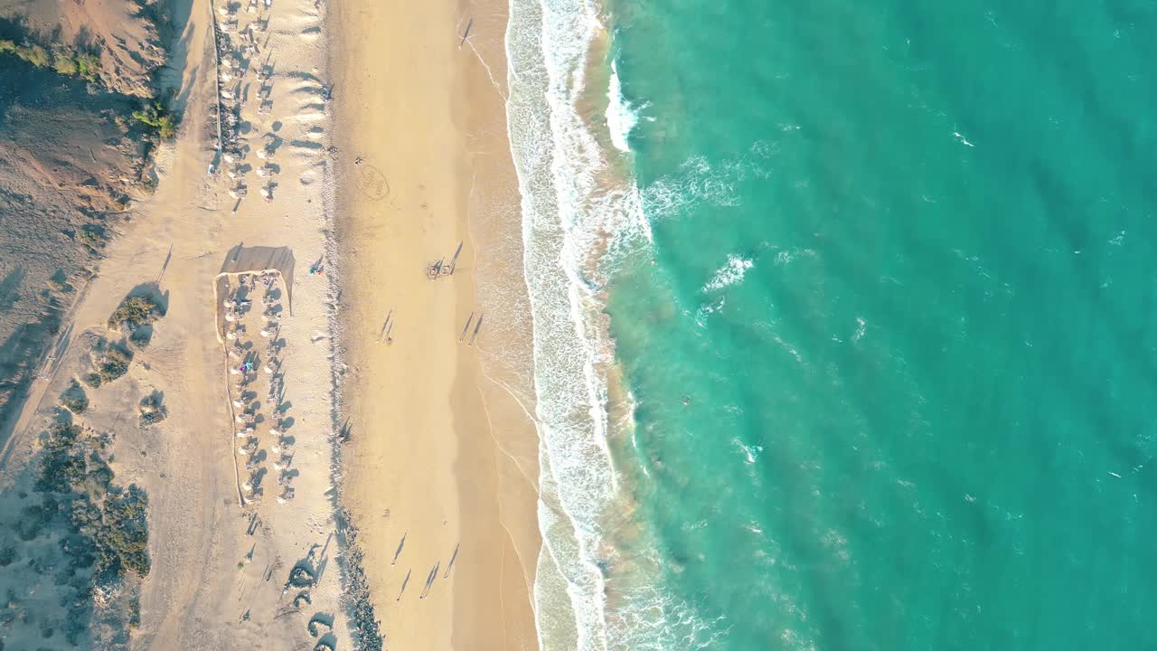 夏天的海景美丽的波浪，蓝色的海水在阳光明媚的日子。西班牙，加那利岛，埃斯昆佐海滩。海上鸟瞰图，热带自然美丽明亮的海浪飞溅和沙滩沙滩夕阳视频素材