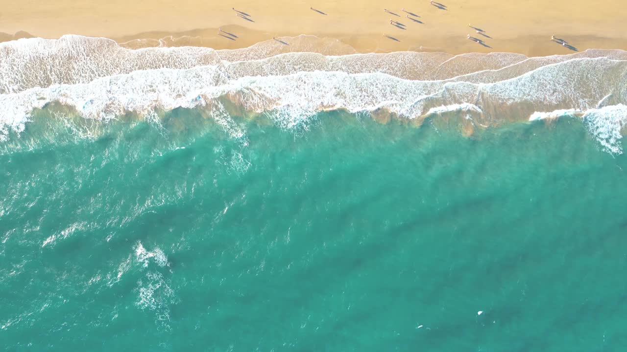 夏天的海景美丽的波浪，蓝色的海水在阳光明媚的日子。西班牙，加那利岛，埃斯昆佐海滩。海上鸟瞰图，热带自然美丽明亮的海浪飞溅和沙滩沙滩夕阳视频素材