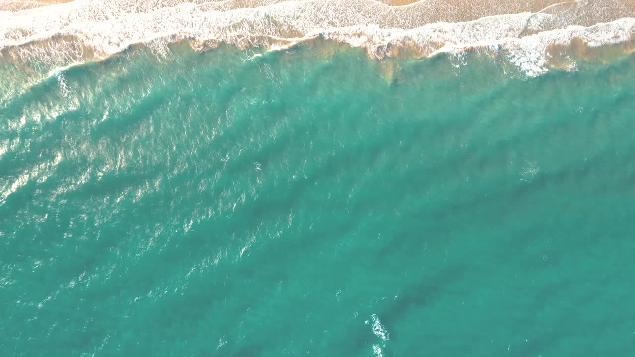 夏天的海景美丽的波浪，蓝色的海水在阳光明媚的日子。西班牙，加那利岛，埃斯昆佐海滩。海上鸟瞰图，热带自然美丽明亮的海浪飞溅和沙滩沙滩夕阳视频素材