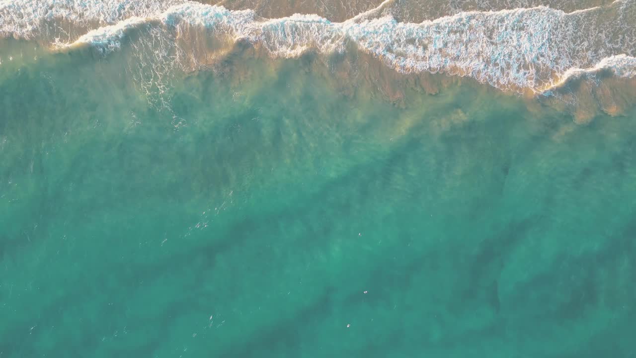 夏天的海景美丽的波浪，蓝色的海水在阳光明媚的日子。西班牙，加那利岛，埃斯昆佐海滩。海上鸟瞰图，热带自然美丽明亮的海浪飞溅和沙滩沙滩夕阳视频素材