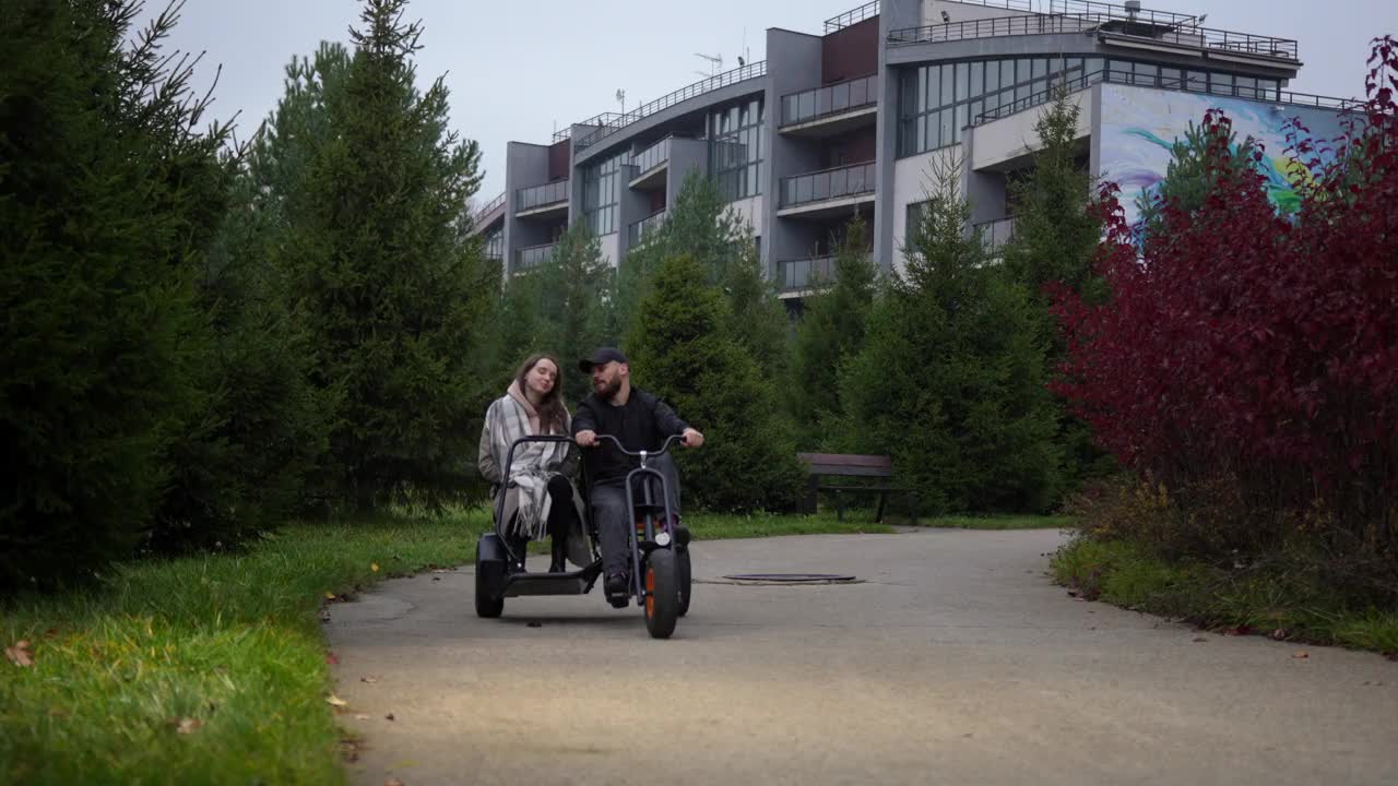 一对夫妇在公园里骑双座三轮车。骑自行车、出租车在城市里旅行视频下载