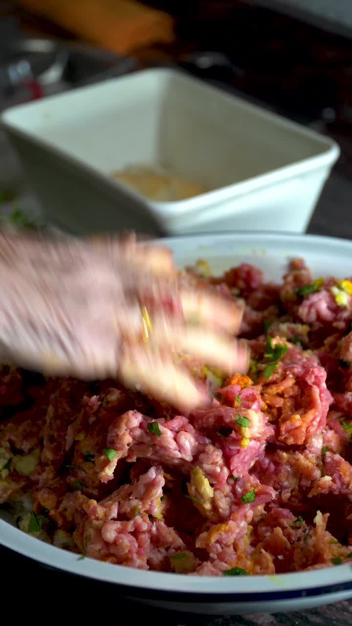 用肉末和一些配料准备肉丸的人。视频素材