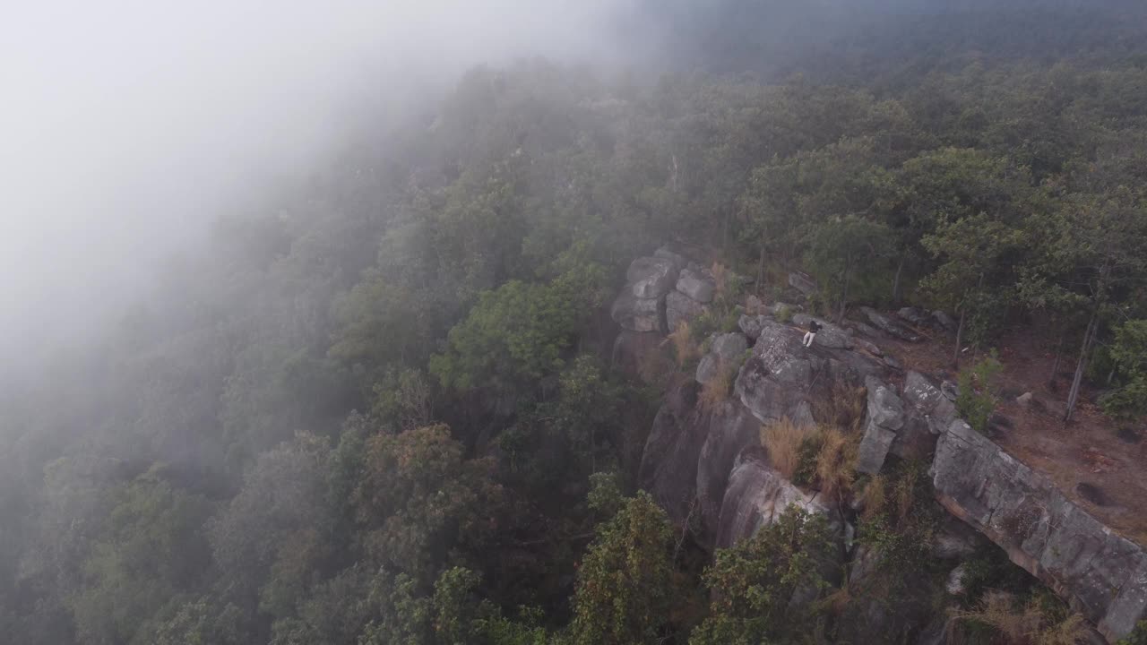 在泰国的冬季旅行中，无人驾驶飞机飞过云雾缭绕的山脉中的悬崖。自然、景观、旅游理念视频下载