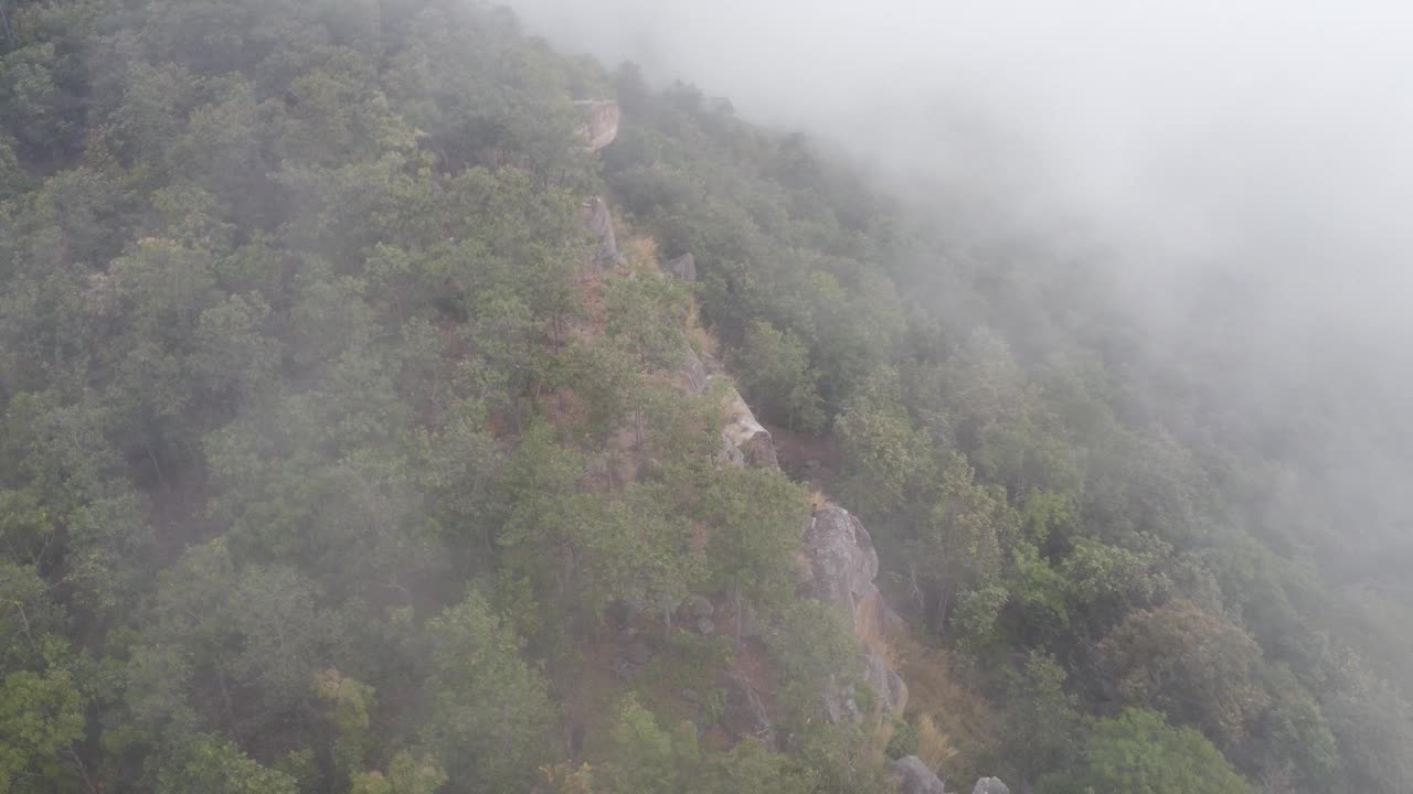 在泰国的冬季旅行中，无人驾驶飞机飞过云雾缭绕的山脉中的悬崖。自然、景观、旅游理念视频下载