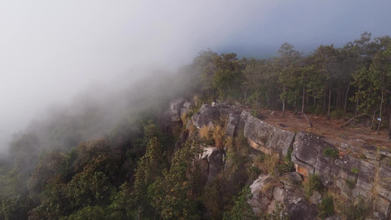 在泰国的冬季旅行中，无人驾驶飞机飞过云雾缭绕的山脉中的悬崖。自然、景观、旅游理念视频下载