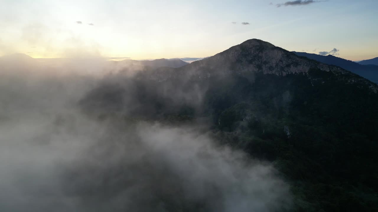 空中拍摄的低云与晨光中起伏的山丘和谐视频素材