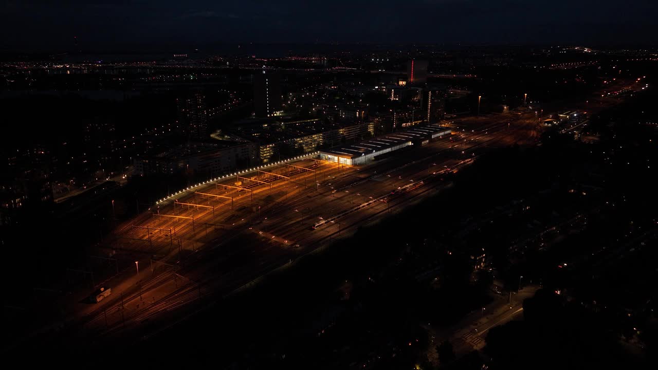 夜间火车站的航拍无人机视图。铁路站场、公路养护、交通运输及铁路基础设施。视频素材