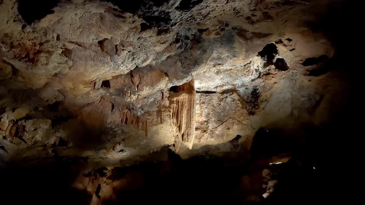 被光线照射的洞穴钟乳石。天花板上有钟乳石的洞穴视频素材