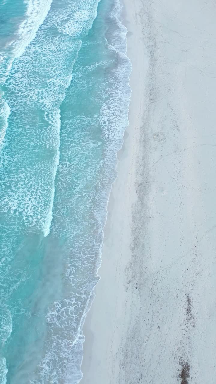 海滩岸边海浪无人机视图垂直拍摄视频素材