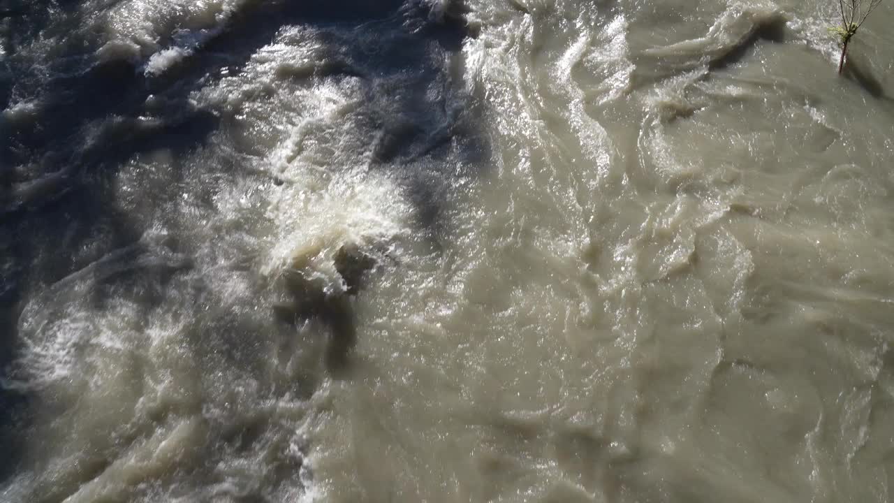 暴雨后河水暴涨的无人机鸟瞰图。水流得很快。有淹水和溢出的危险。一般的河流洪水竞赛视频下载