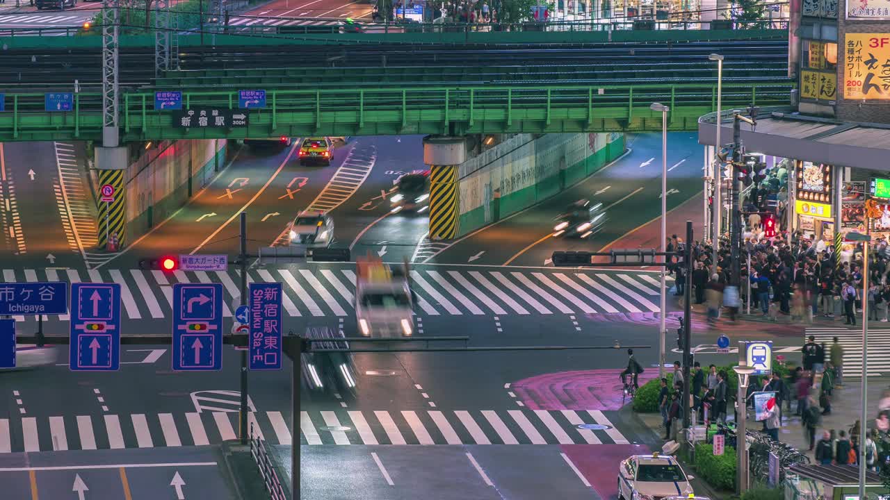 在日本东京新宿，许多行人和车辆在繁忙的街道路口行走。亚洲城市生活方式商务交通概念。视频下载