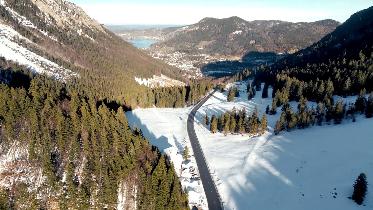 令人惊叹的空中无人机视图:白雪覆盖的山口，风景秀丽的施利尔湖在德国，巴伐利亚阿尔卑斯山景观与公路和远山湖在冬季视频素材