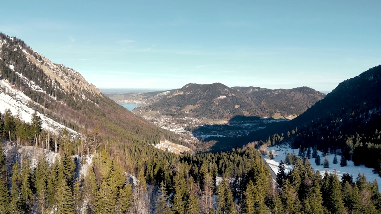 令人惊叹的空中无人机视图:白雪覆盖的山口，风景秀丽的施利尔湖在德国，巴伐利亚阿尔卑斯山景观与公路和远山湖在冬季视频素材