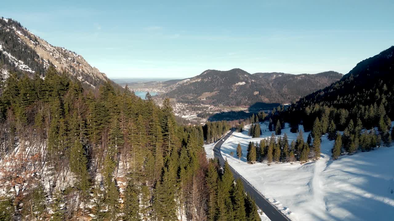 令人惊叹的空中无人机视图:白雪覆盖的山口，风景秀丽的施利尔湖在德国，巴伐利亚阿尔卑斯山景观与公路和远山湖在冬季视频素材