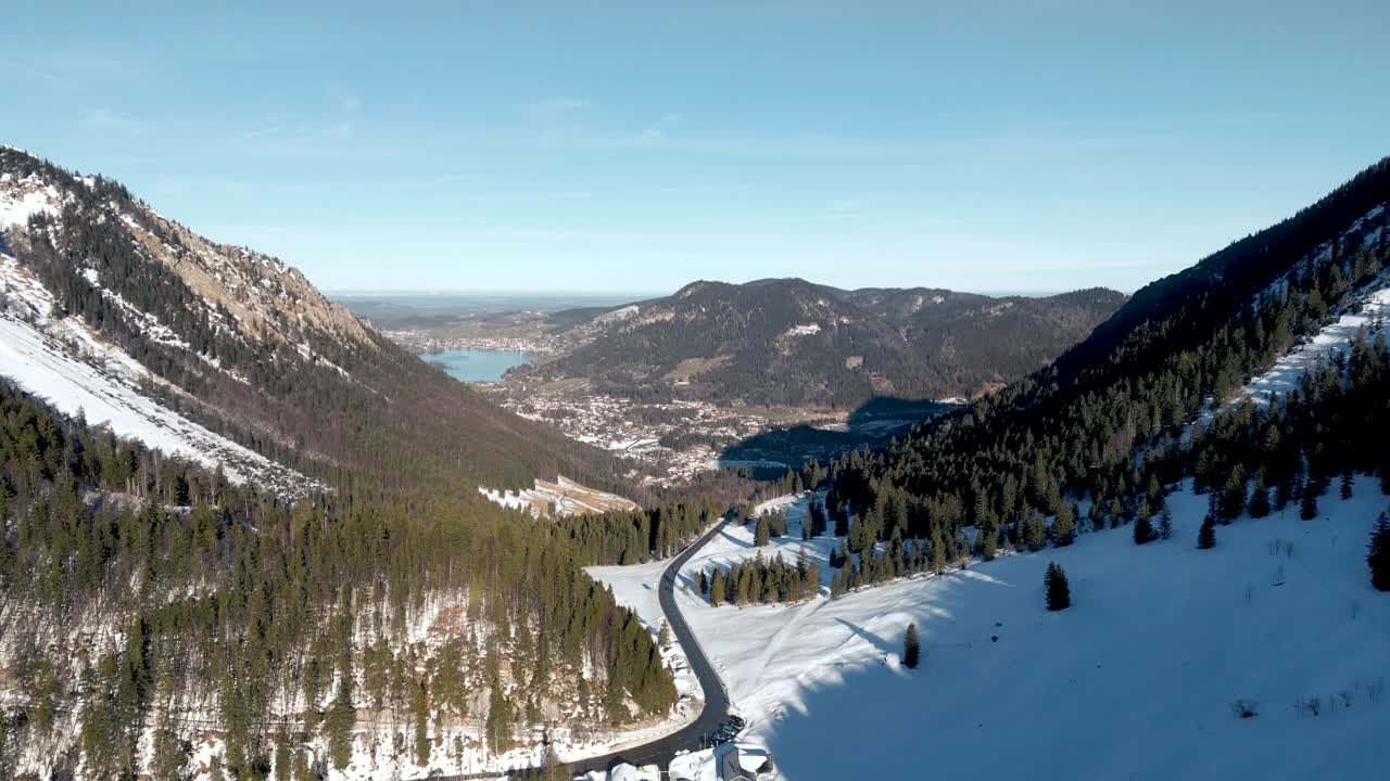 令人惊叹的空中无人机视图:白雪覆盖的山口，风景秀丽的施利尔湖在德国，巴伐利亚阿尔卑斯山景观与公路和远山湖在冬季视频素材