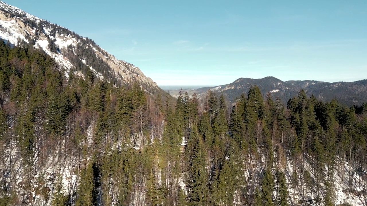 令人惊叹的空中无人机视图:白雪覆盖的山口，风景秀丽的施利尔湖在德国，巴伐利亚阿尔卑斯山景观与公路和远山湖在冬季视频素材