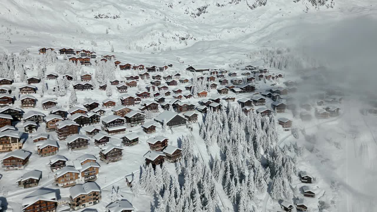 美丽的冬季风景在山上。屋顶上有雪的小茅屋和小屋。冬天的风景视频素材