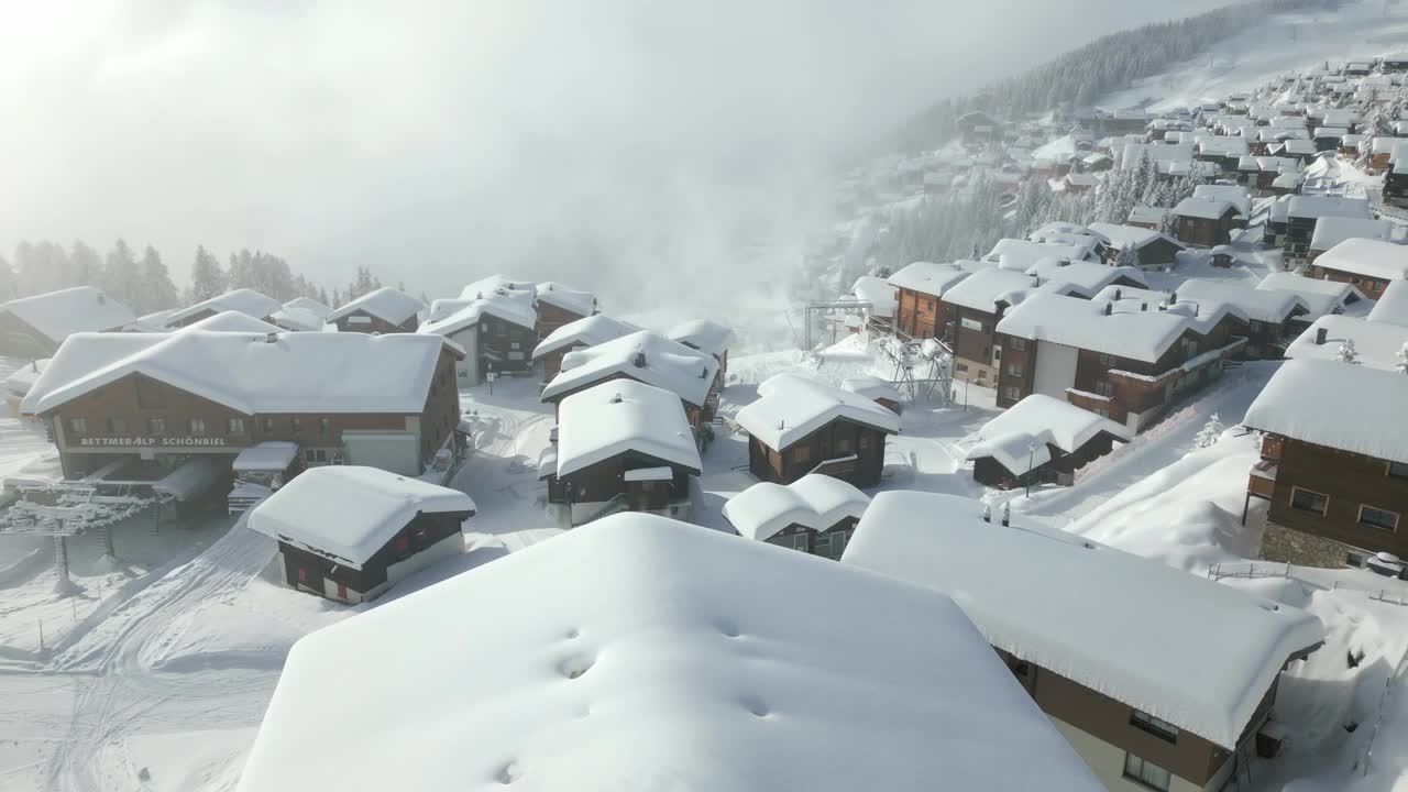 瑞士山区的一个小村庄，冬天有很多雪。屋顶上有雪的小屋。BETTMERALP瑞士视频素材