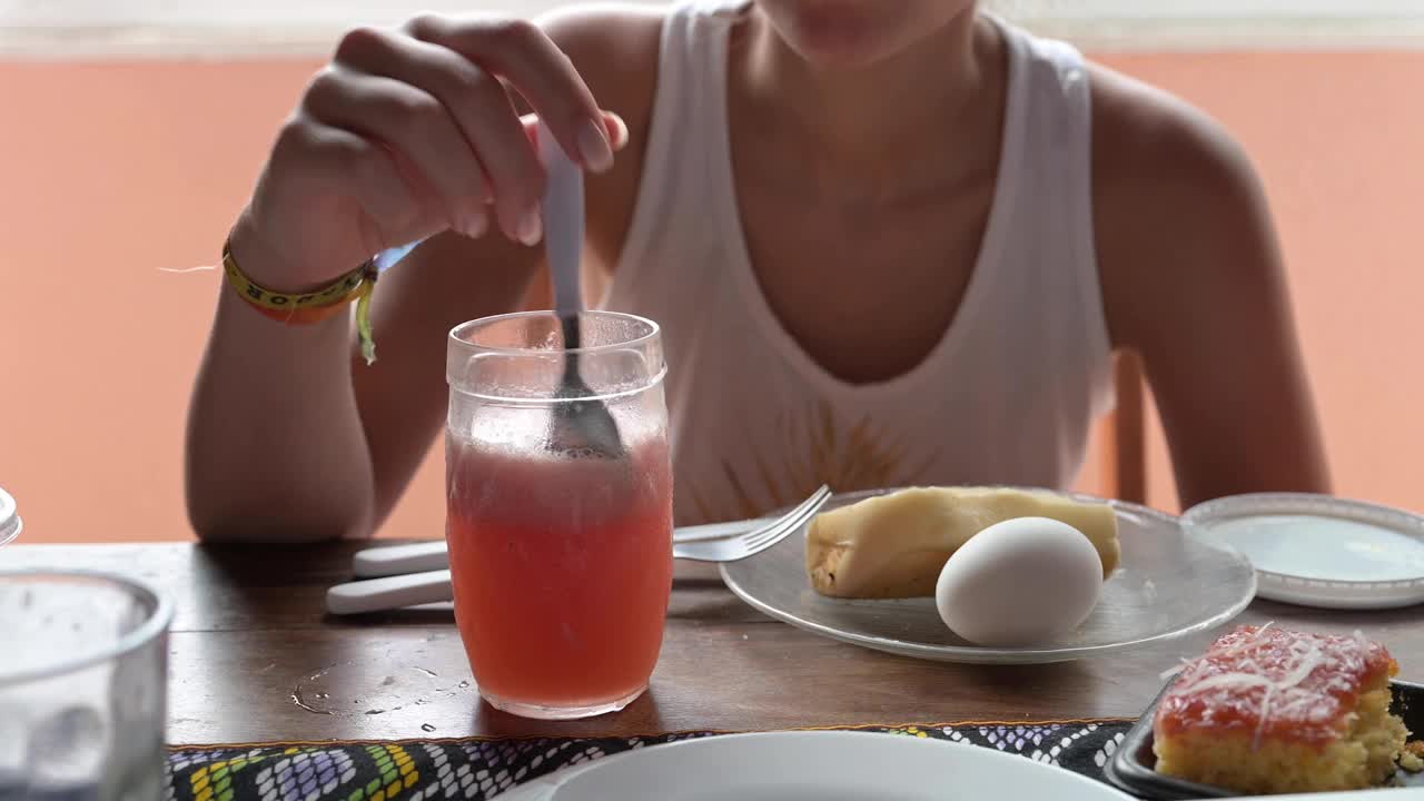 年轻女子在早餐桌上搅拌奶昔视频素材