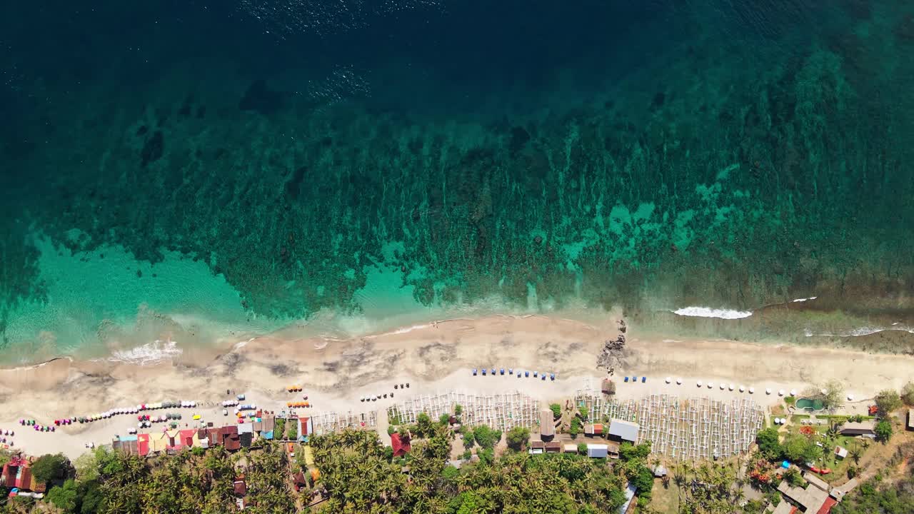 俯瞰美丽的海滩和海底纹理浮雕与绿色的海水在巴厘岛，卡兰加西姆，印度尼西亚视频素材