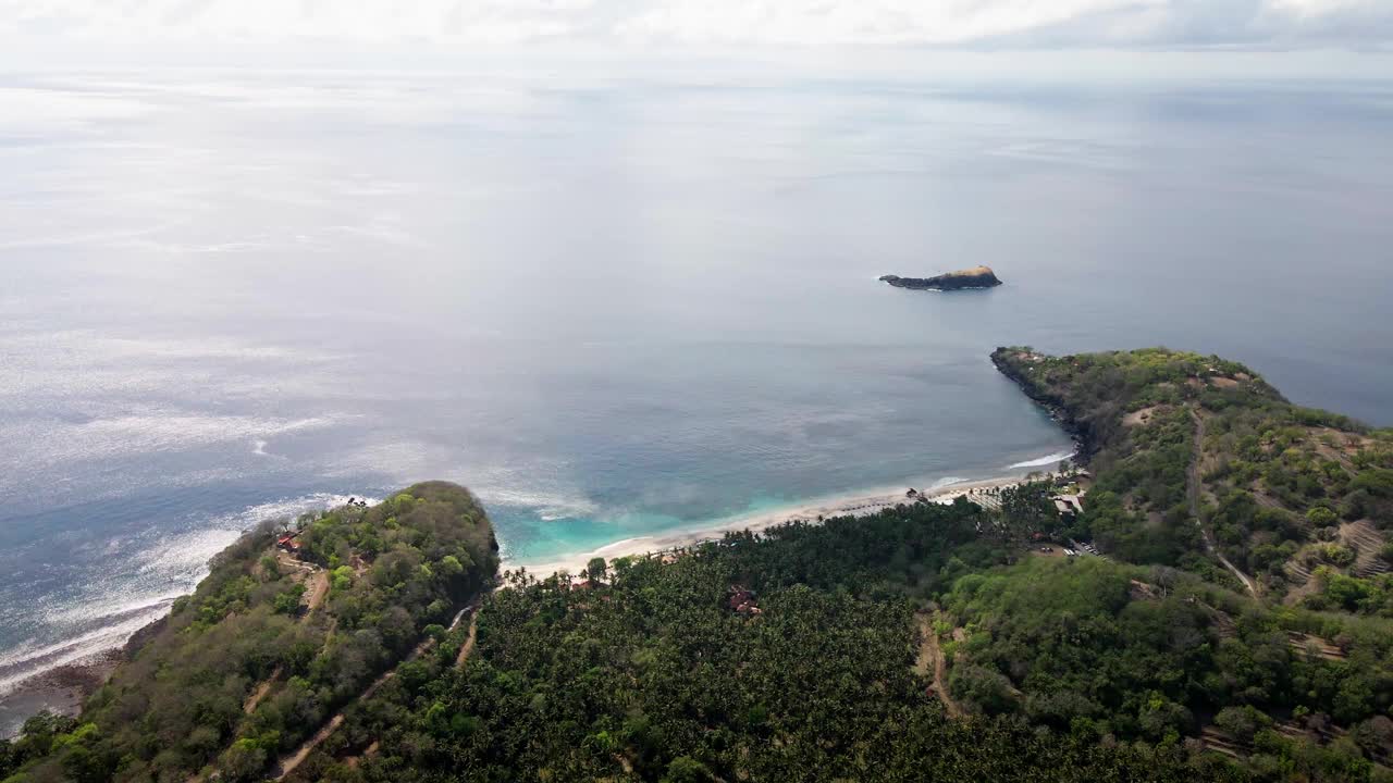 摄于印度尼西亚卡兰加西岛东巴厘岛的处女海滩海湾。梦想之旅户外探险。野生大自然空中4K。茂密的棕榈树丛林和透明的绿色海水视频素材