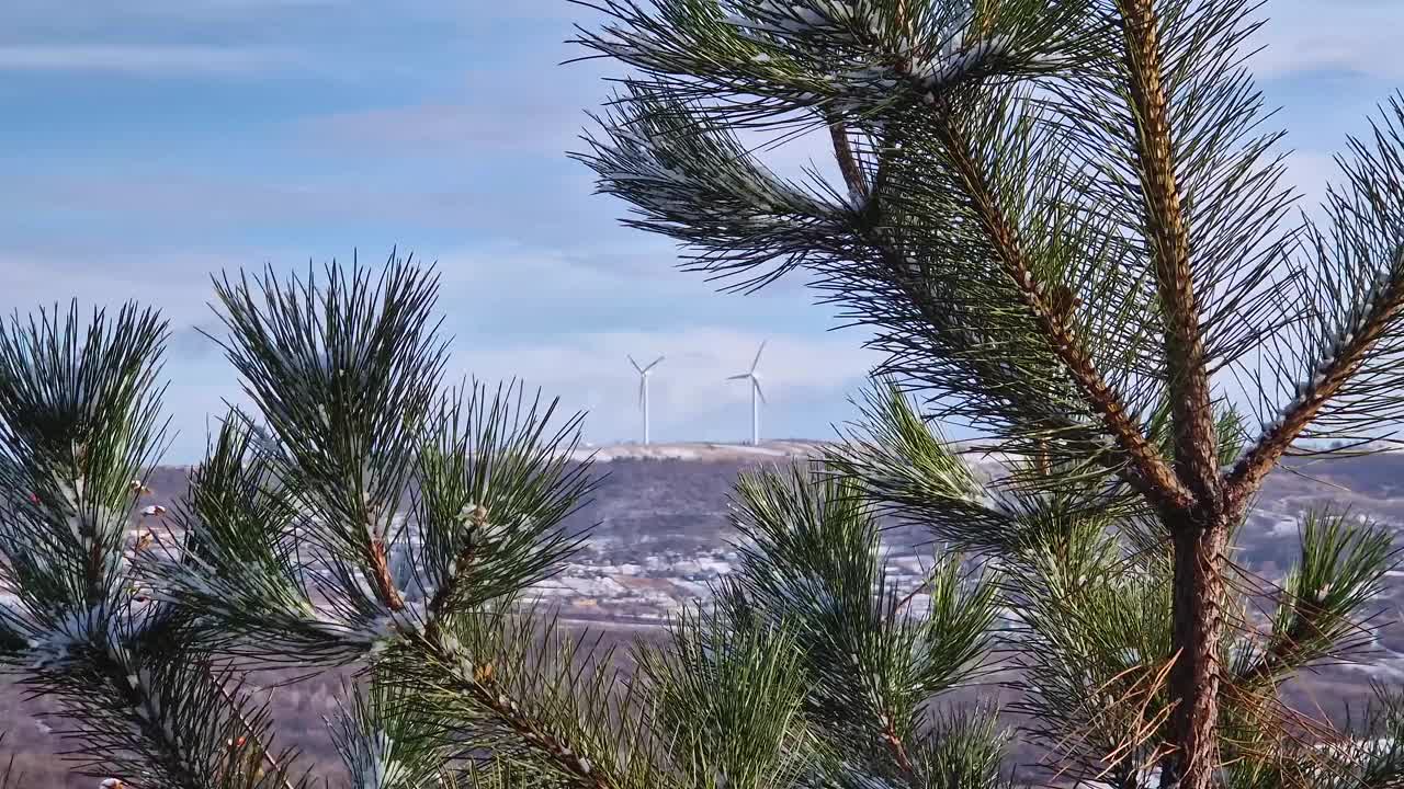 摩尔多瓦的乡村山谷里有许多小村庄，在白雪覆盖的小山顶上，风力涡轮机在旋转视频素材