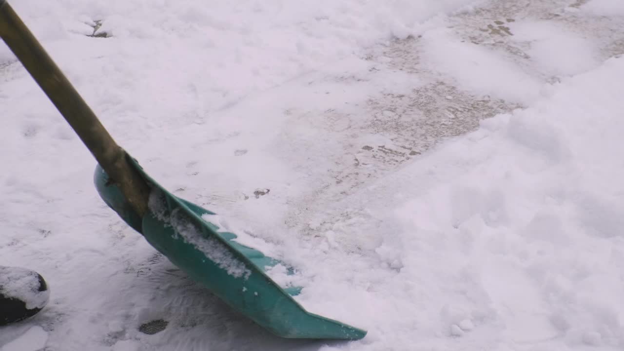 一个人在用铲子清理积雪。有选择性的重点。大自然。视频素材