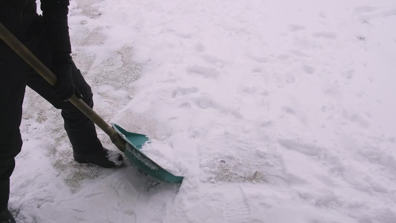 一个人在用铲子清理积雪。有选择性的重点。大自然。视频素材