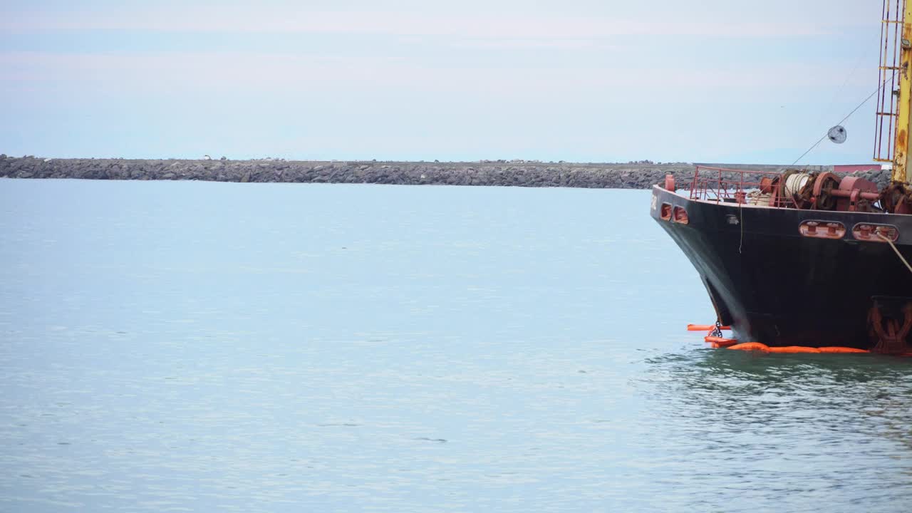 船首停泊在海港，海浪冲刷着运输渡轮、集装箱船或驳船的船尾。海运，国际贸易视频素材