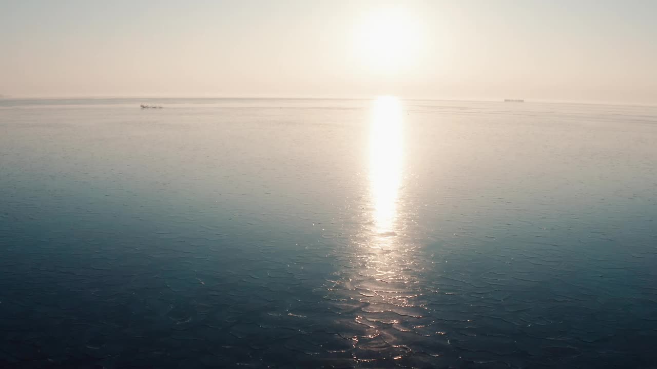 在阳光下沿着结冰的湖面飞行视频下载