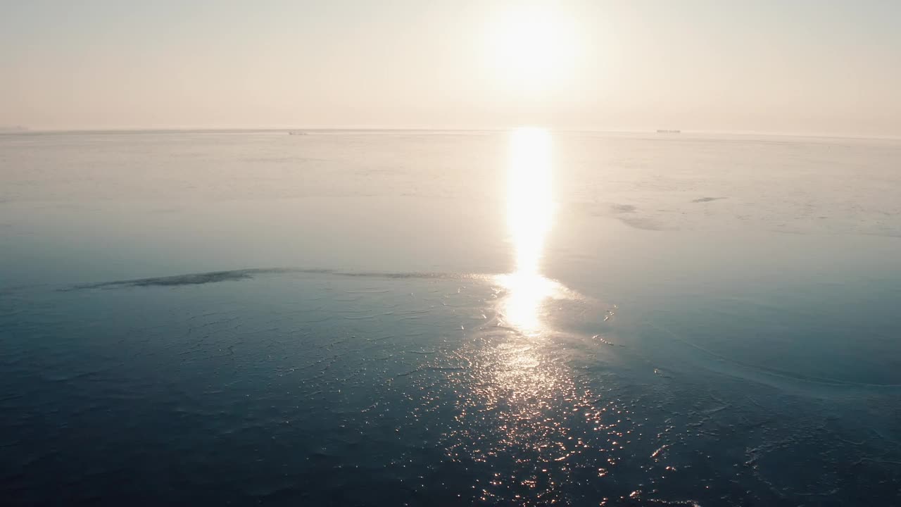 在阳光下沿着结冰的湖面飞行视频下载