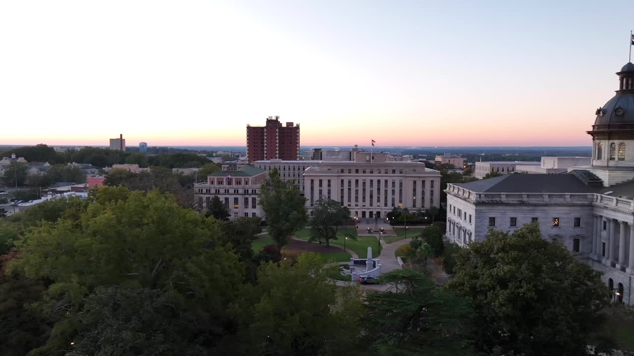 日出时分，南卡罗来纳州哥伦比亚市的南卡罗来纳州议会大厦和国会大厦。卡车航拍。视频素材