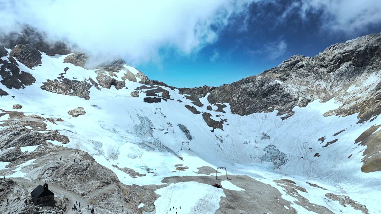 鸟瞰白雪覆盖的楚格峰，德国最高的山峰——巴伐利亚高山的美丽是中心焦点，蓝天白云在背景中视频素材