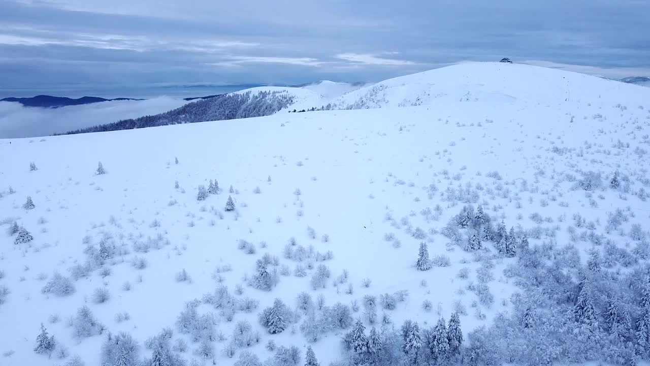 空中拍摄的冬季景观揭示了法国上孚日地区白雪皑皑的霍内克峰和云层视频素材