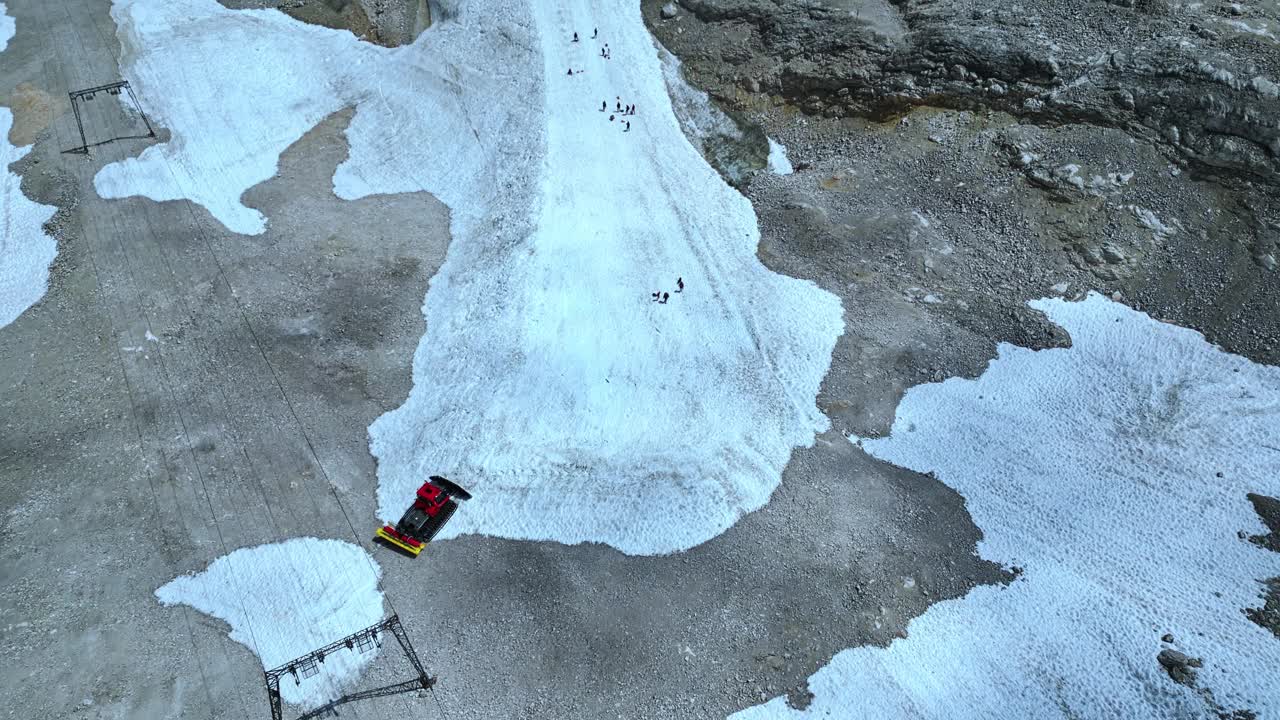 鸟瞰冬季活动，人们在积雪覆盖的山上滑雪，旁边是干燥的山岩视频素材