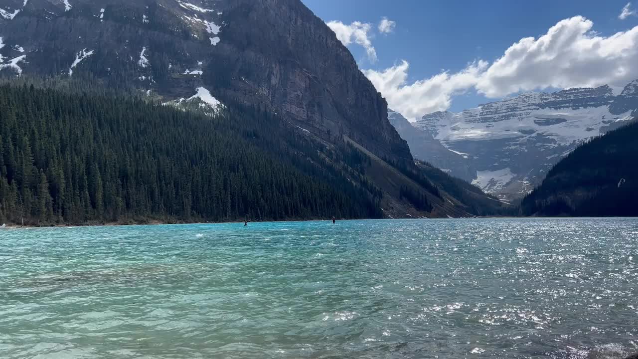 在远处的加拿大路易斯湖玩桨板视频素材