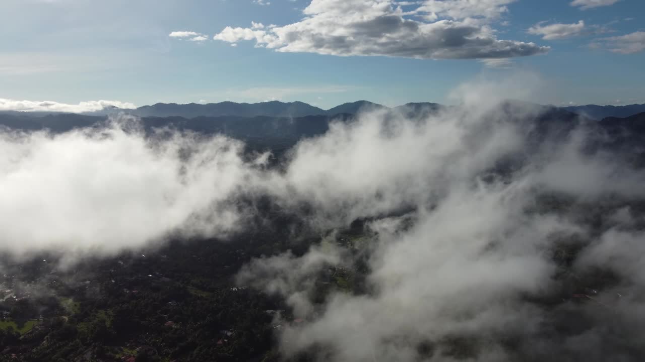 航拍照片展示了沉浸在低云毯子中的山的宁静之美视频素材