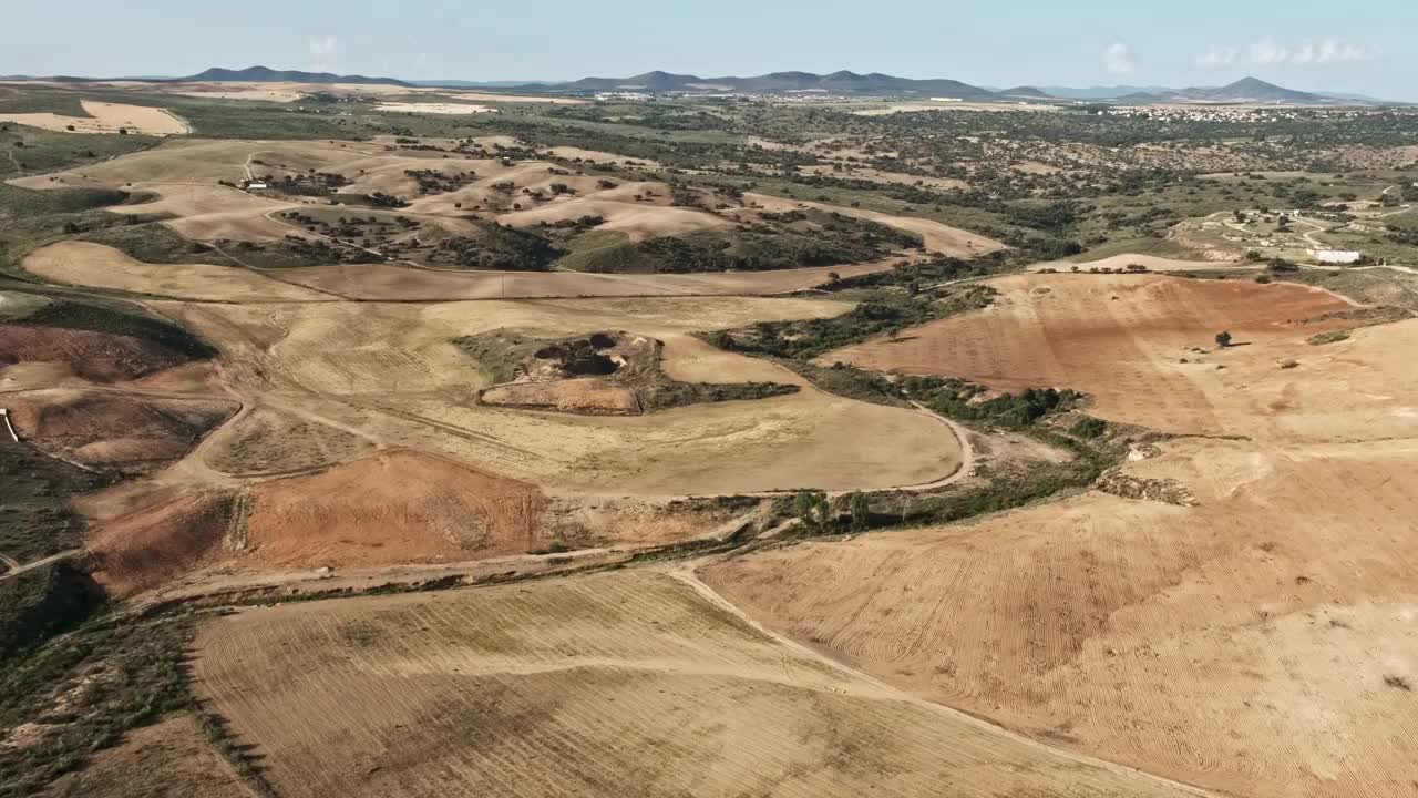 航空视频的田野赭石色调与山在蓝天的背景视频下载