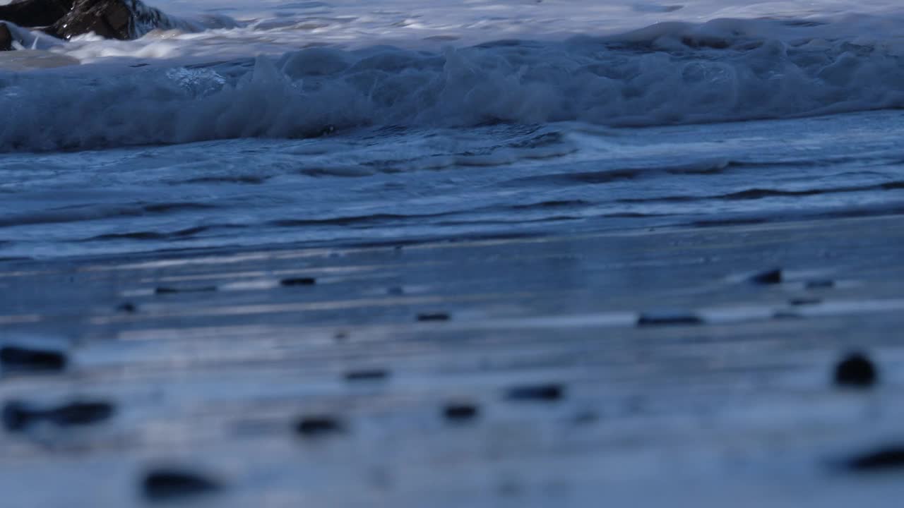 夕阳下，柔和的海浪慢慢地拍打着海滩视频下载