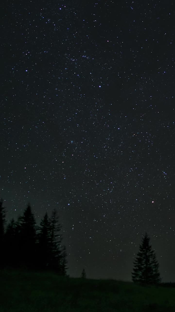 移动的云和星星在夜空中越过山脉的时间流逝视频素材