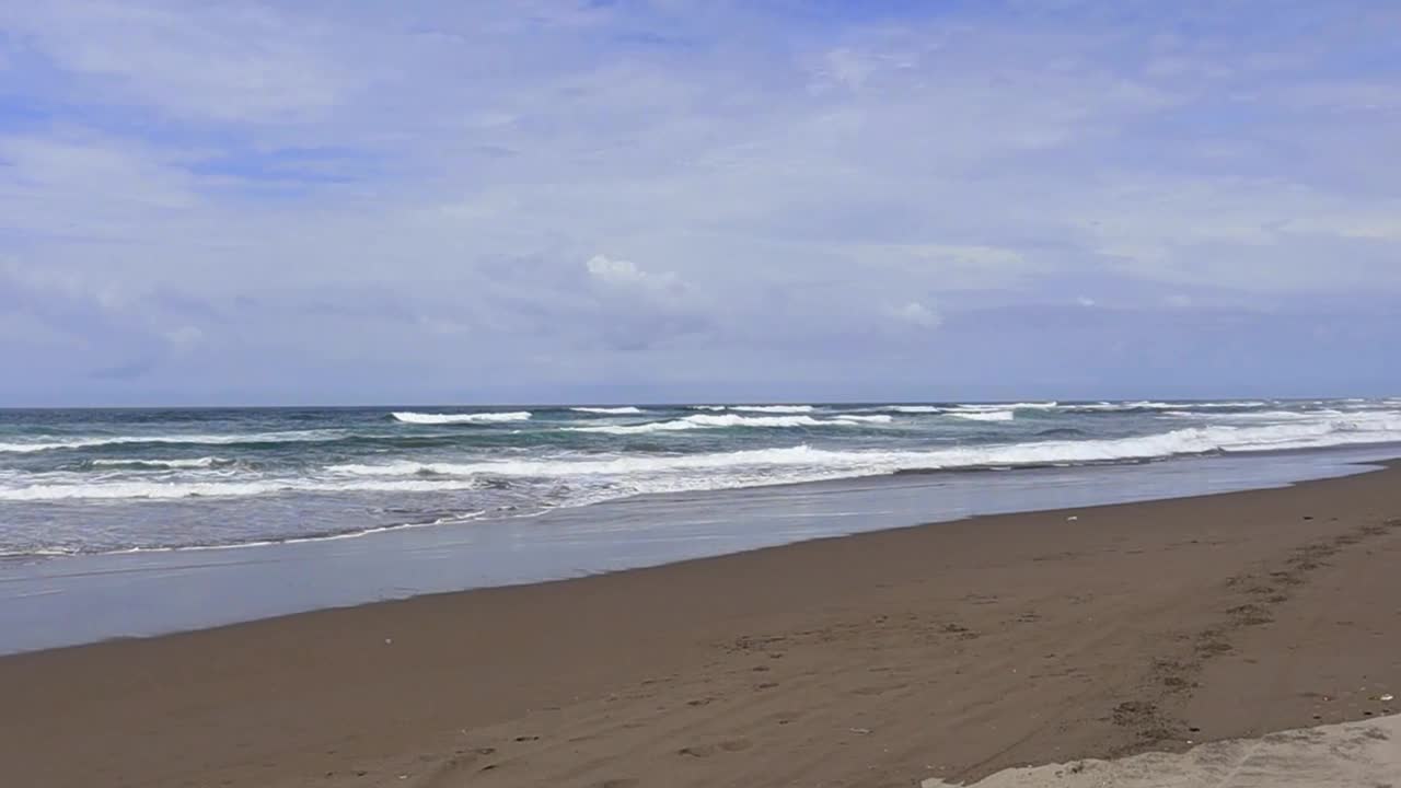 夏日沙滩、海沙和天空的景观景观。沿海海域。在日惹的Parangtritis海滩视频素材