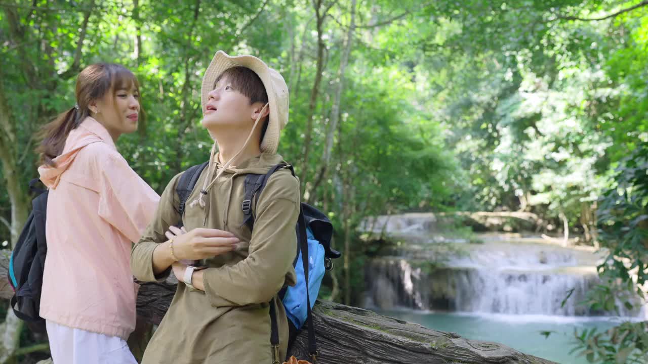 一群亚洲年轻人一起在热带森林徒步旅行。视频素材