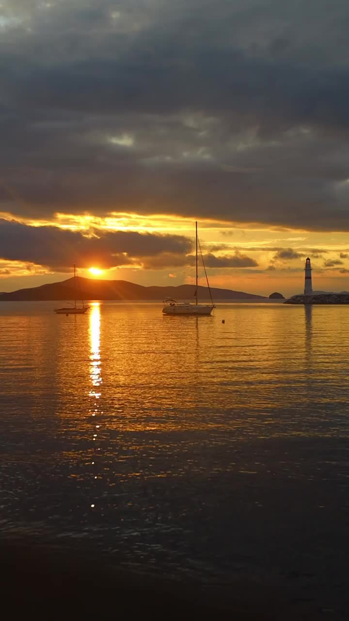 日落时的海景。海岸上的灯塔。海滨小镇Turgutreis和壮观的日落。社交媒体的垂直视频。视频素材